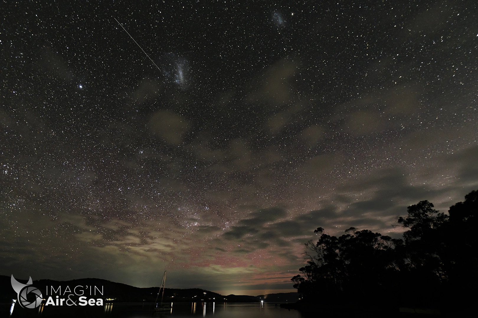 Photo de nuit dévoilant une aurore australe et un ciel étoilé dans le sud de la Tasmanie