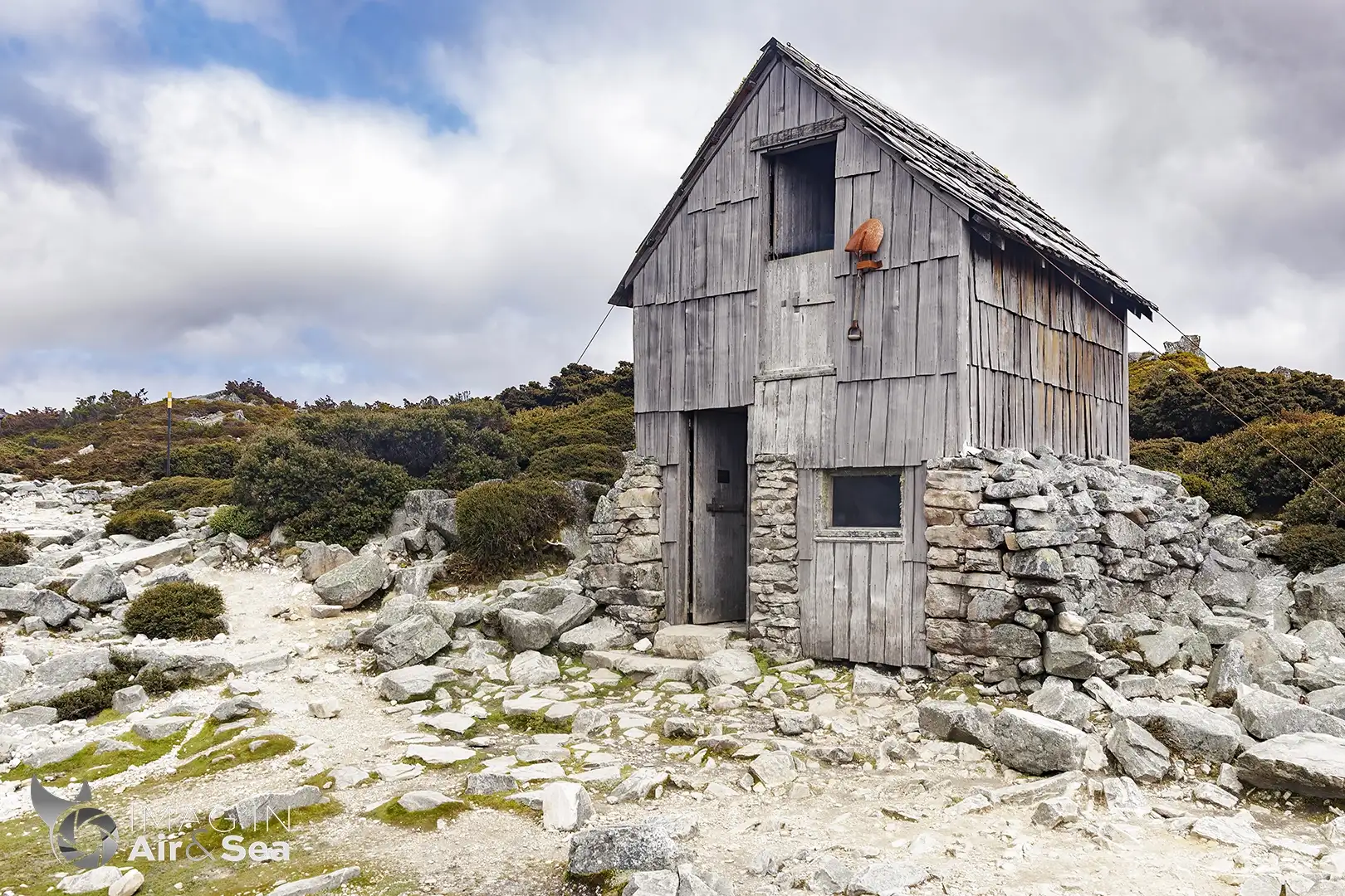 Photo de l'emblématique Kitchen Hut au pied du mont Cradle sous un ciel chargé