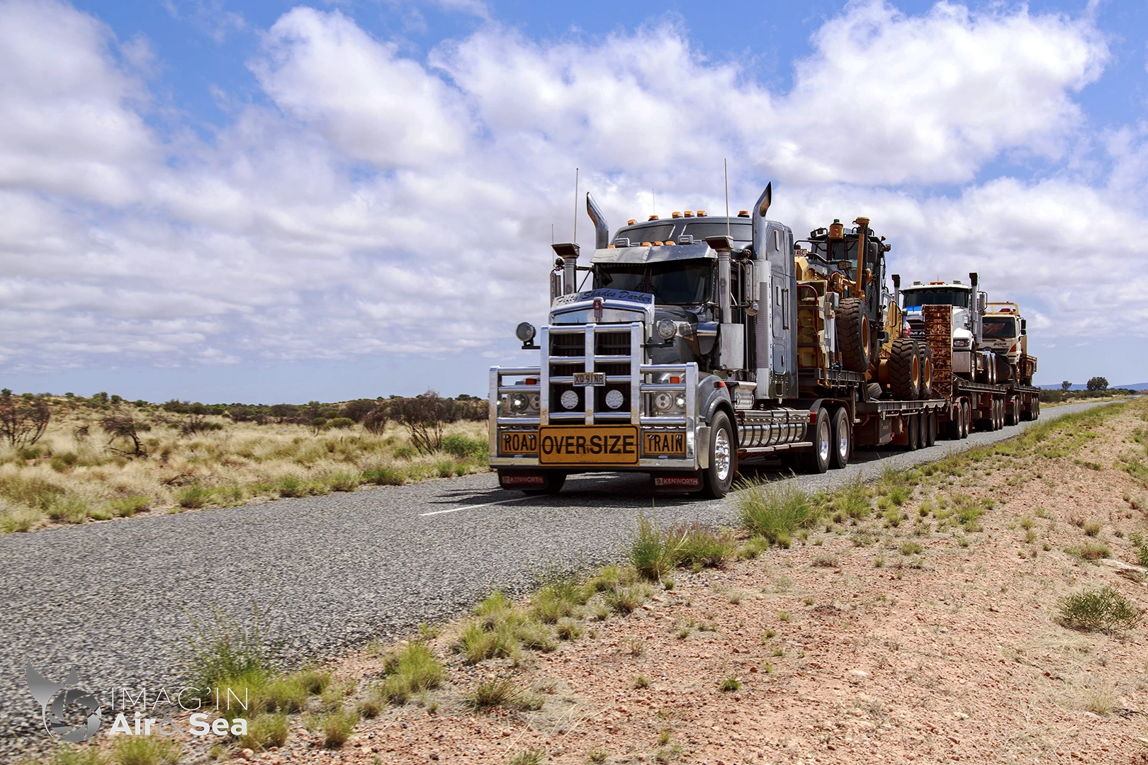 Photographie d'un des nombreux Road Train transportant des engins de chantier et véhicules qui sillonne les routes du centre de l'Australie
